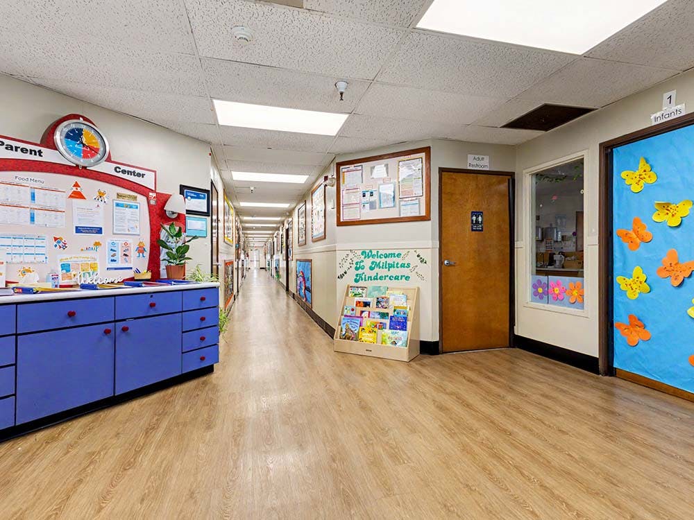 A long hallway in a childcare center with decorations and doors