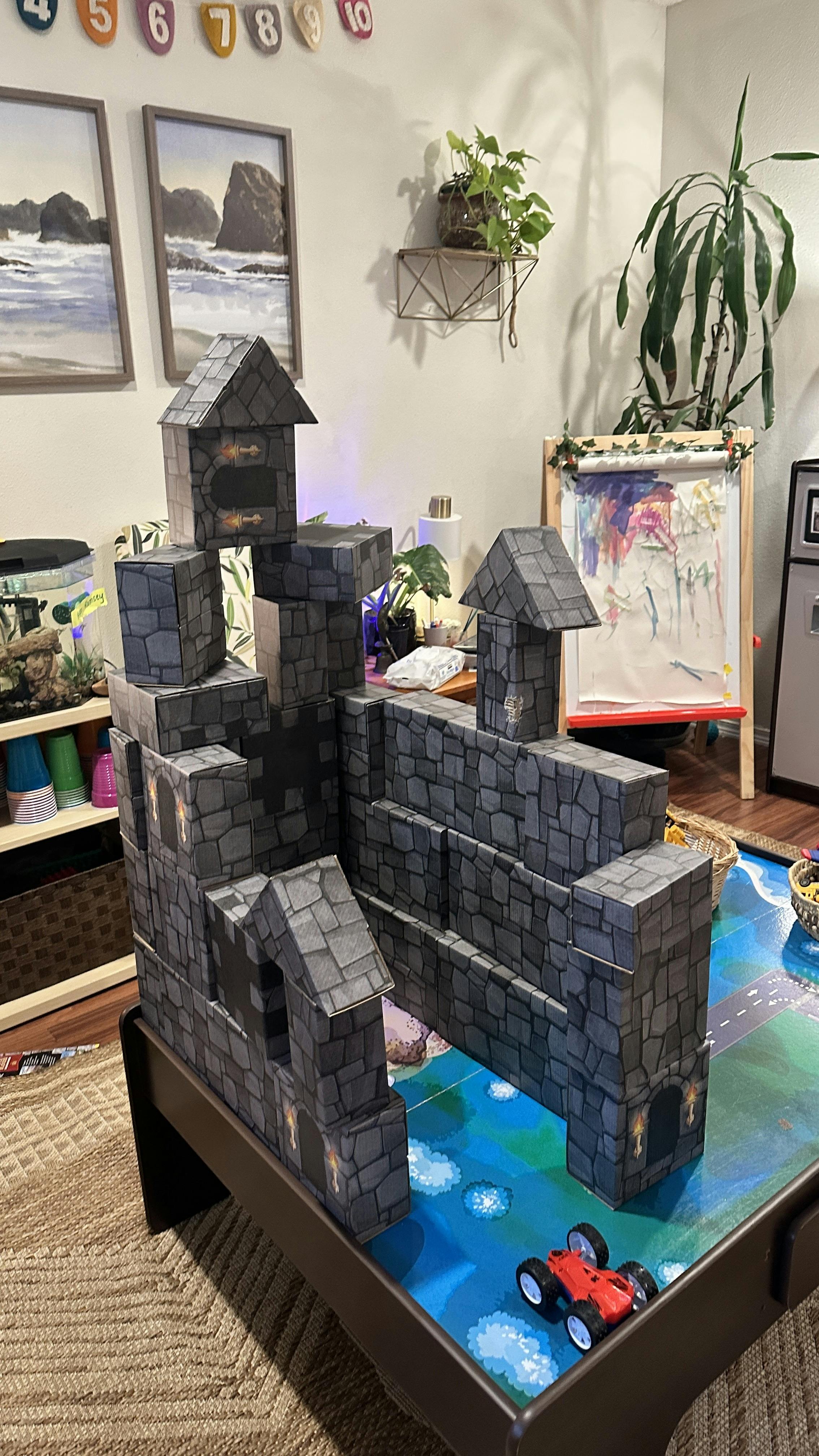 cardboard block castle on a table with a red toy car