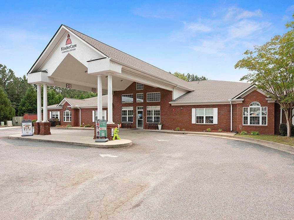 Brick building with a covered entrance and sign that reads KinderCare Learning Centers