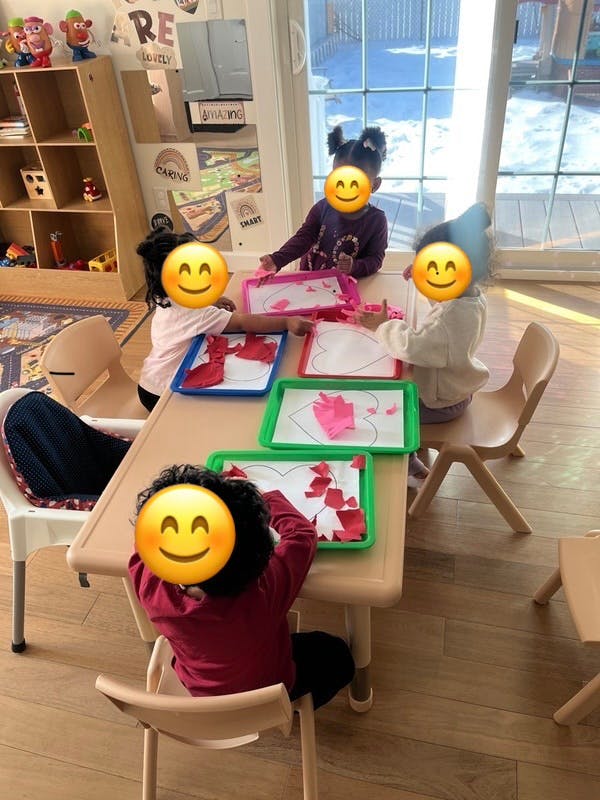 Children doing an art project with heart-shaped cutouts
