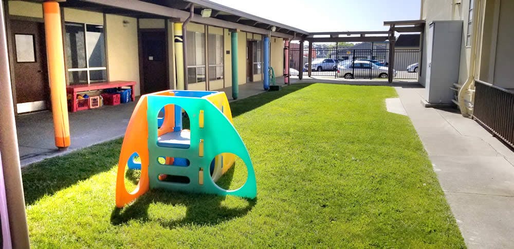 Colorful plastic play structure on a grassy area outside area