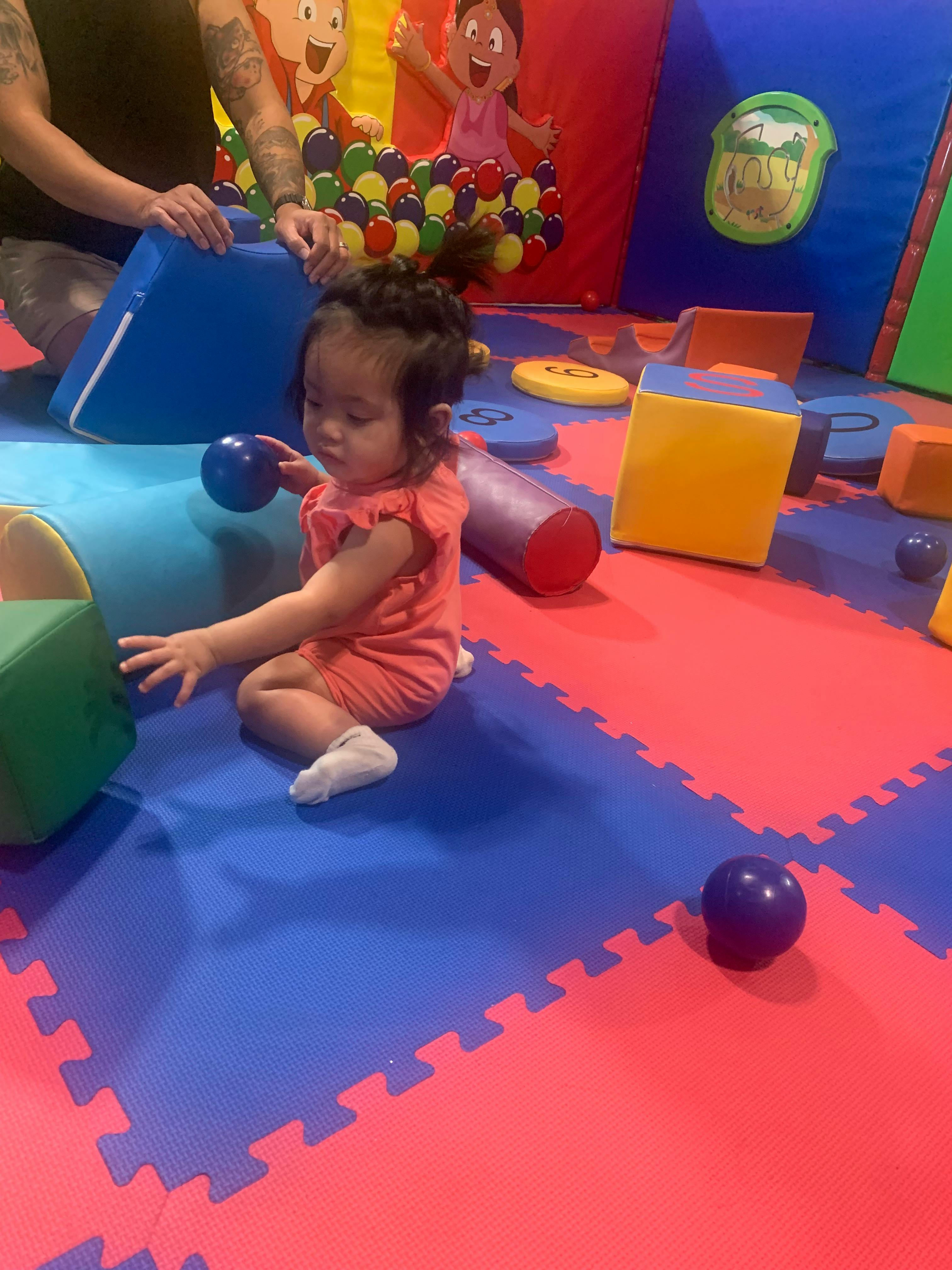 Child playing with foam blocks on a colorful mat