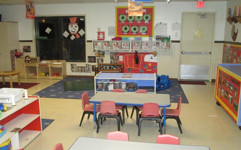 Classroom with child-sized tables and chairs, shelves, and decorations