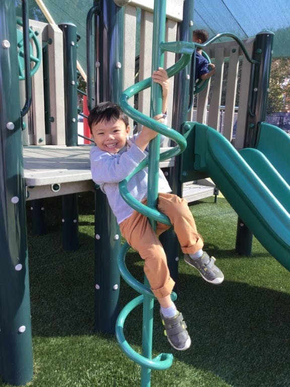 Child on a spiral climbing pole at a playground