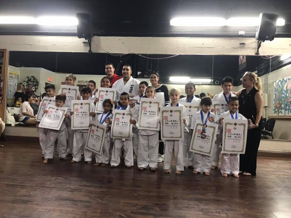 Group of children and adults holding certificates