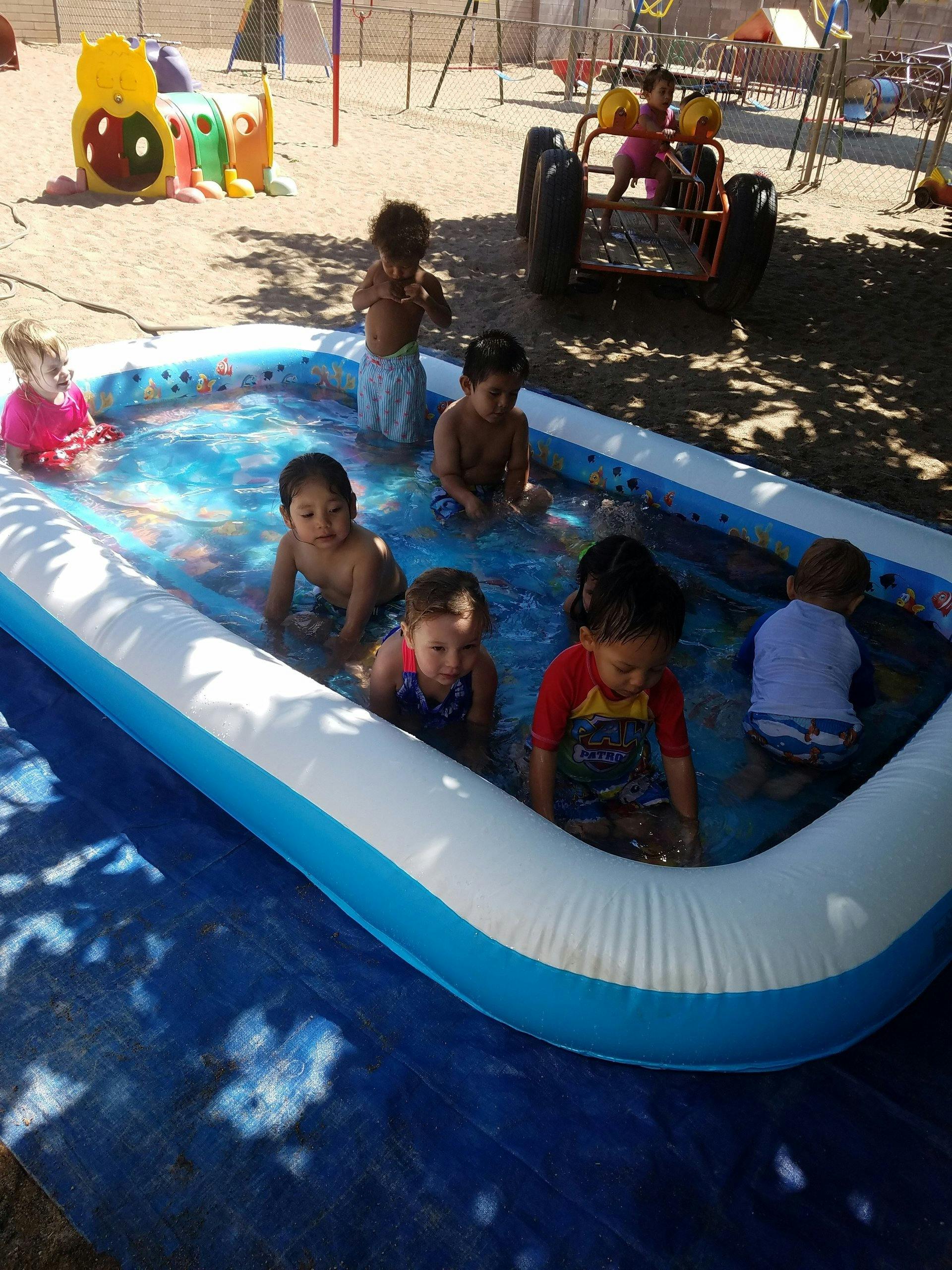 Children playing in an inflatable pool outdoors
