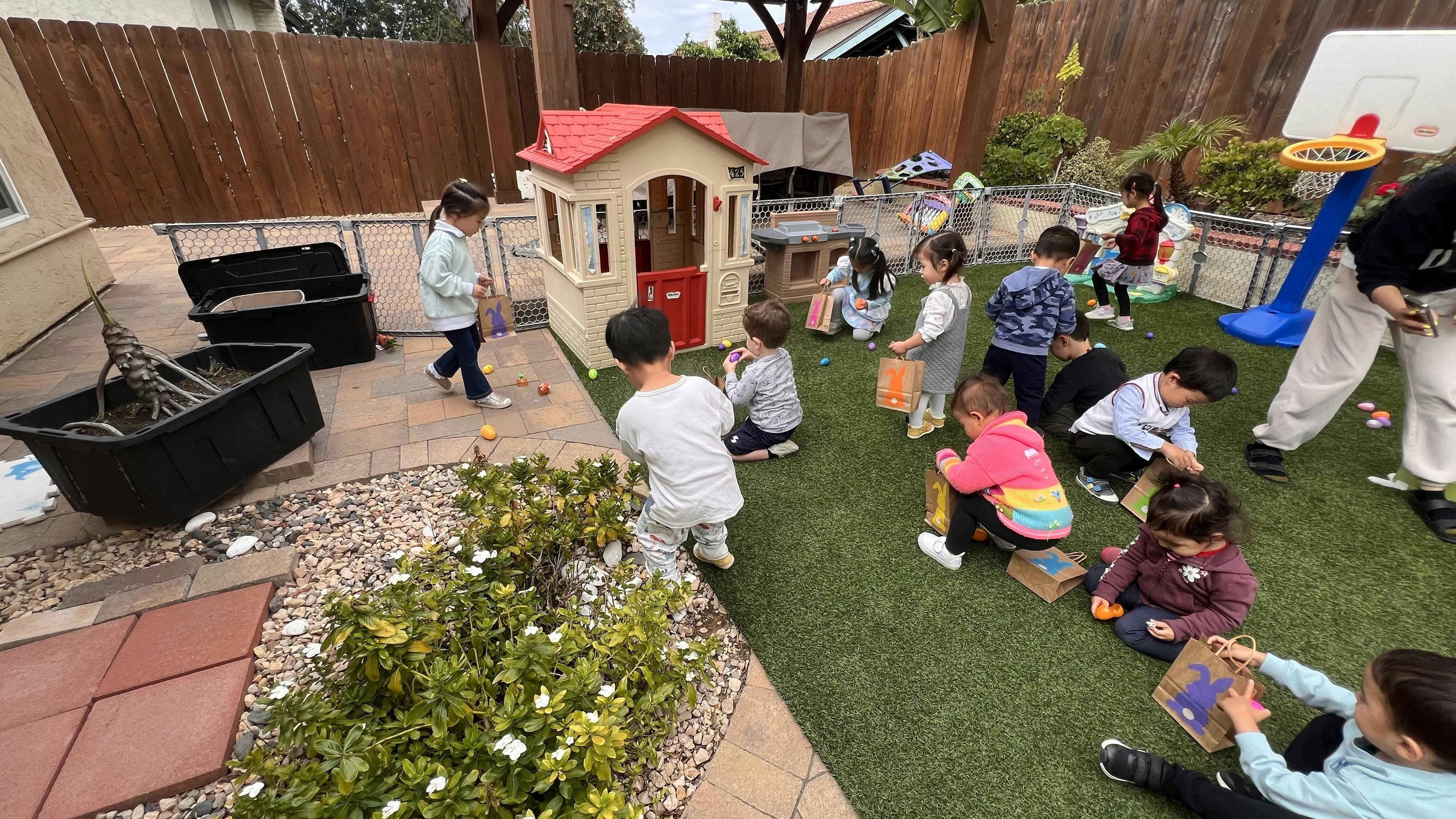 Group of children participating in an Easter egg hunt in a backyard