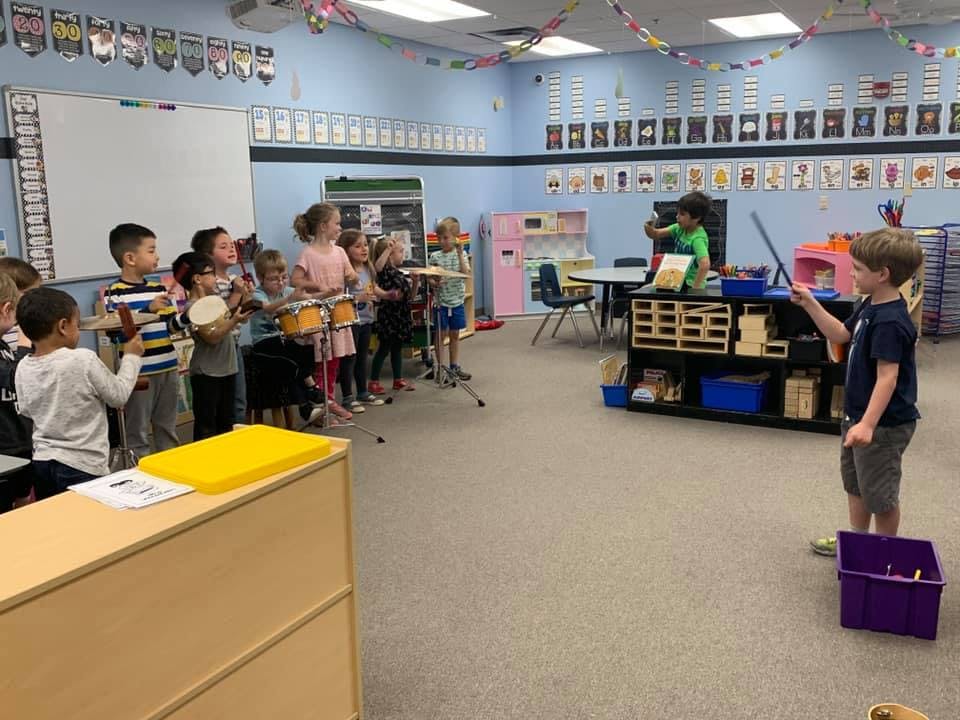Children playing musical instruments in a classroom
