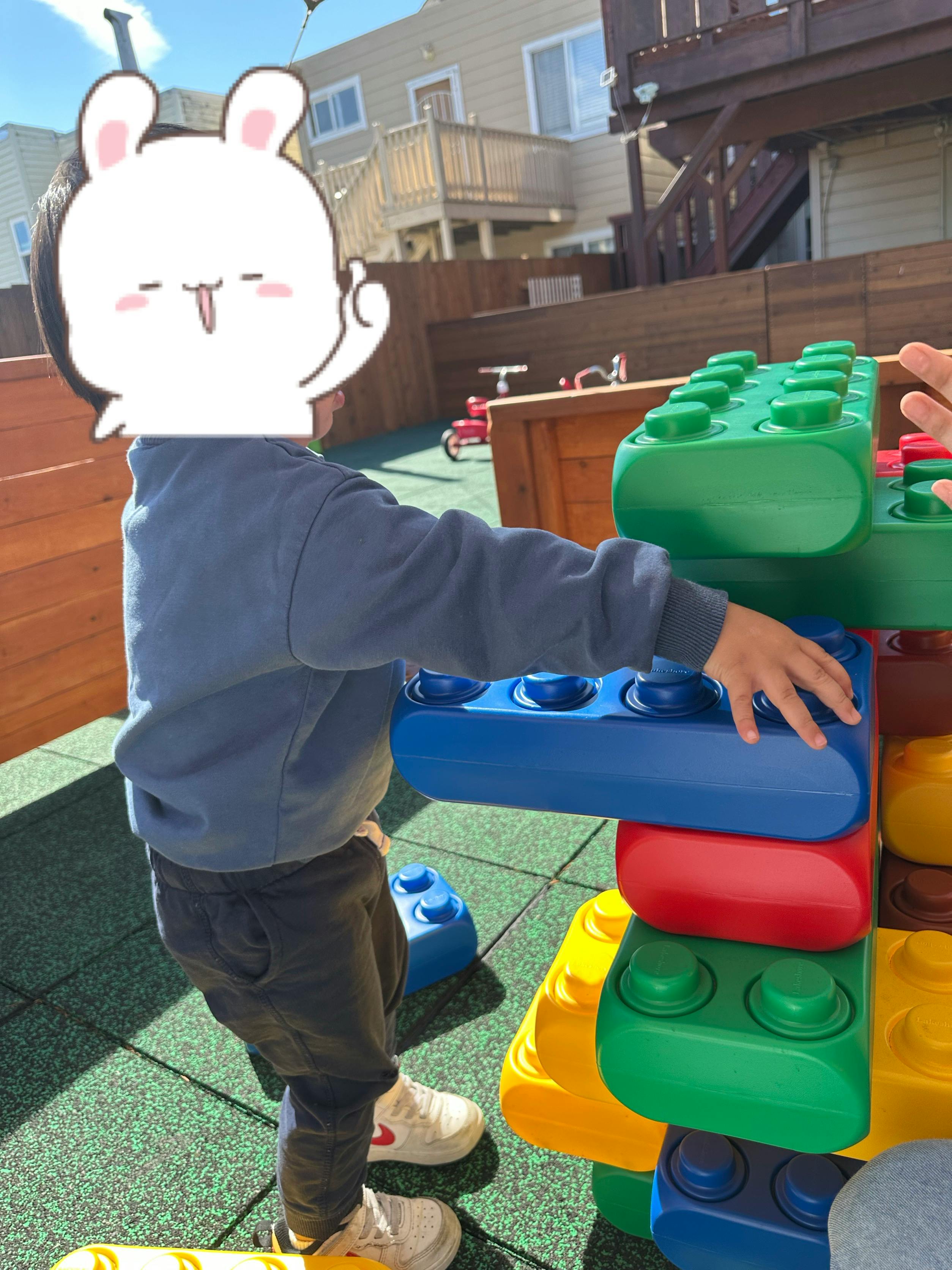 Child playing with large colorful building blocks