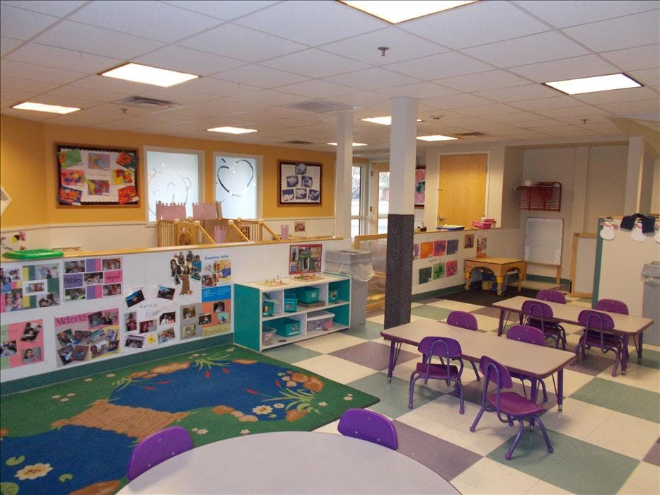 Empty colorful preschool classroom with small tables and chairs