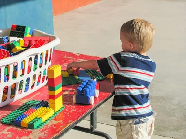Child playing with colorful building blocks on a table