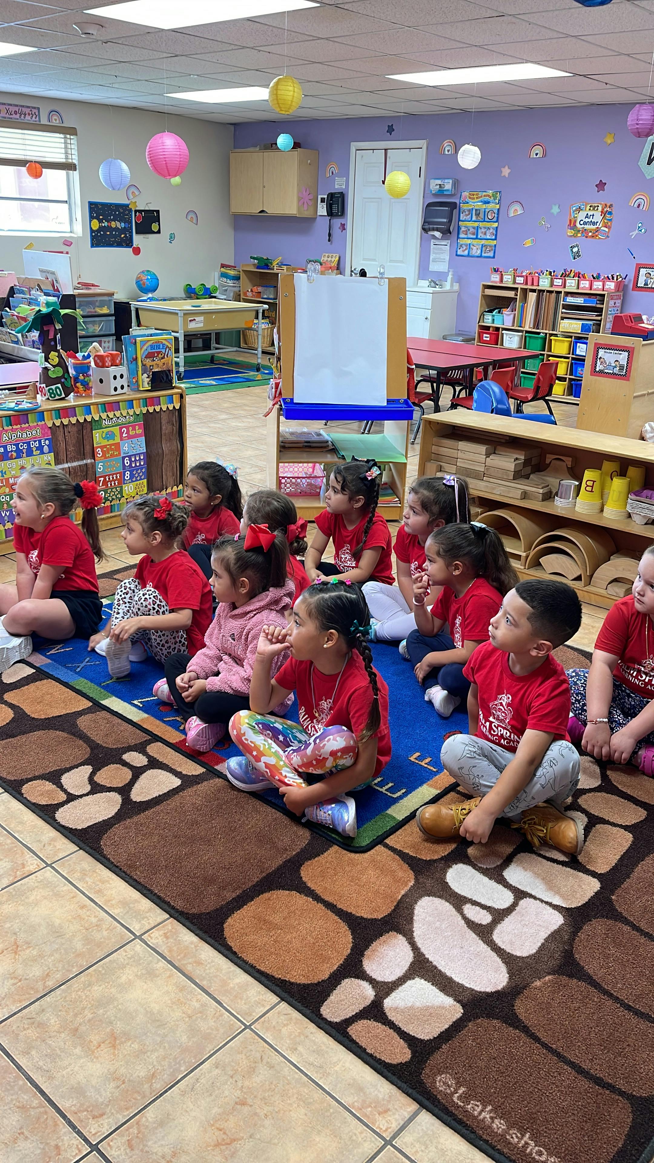 Children sitting on a rug in a classroom