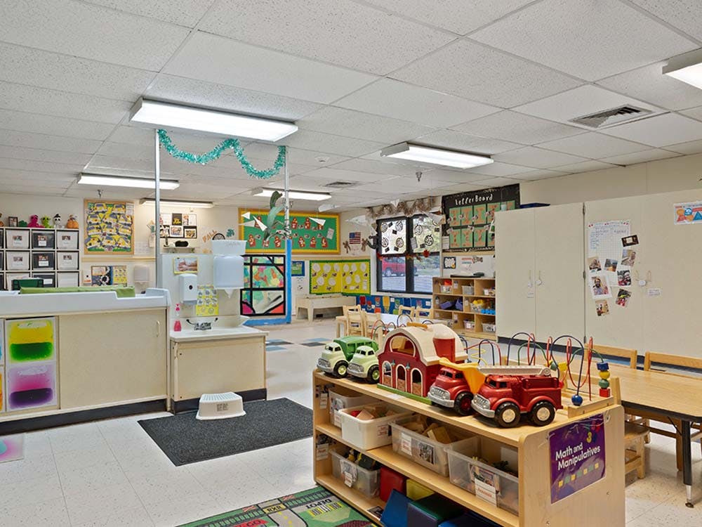 A colorful preschool classroom with a changing table and play areas