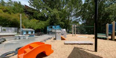Outdoor playground with an orange slide and various play structures