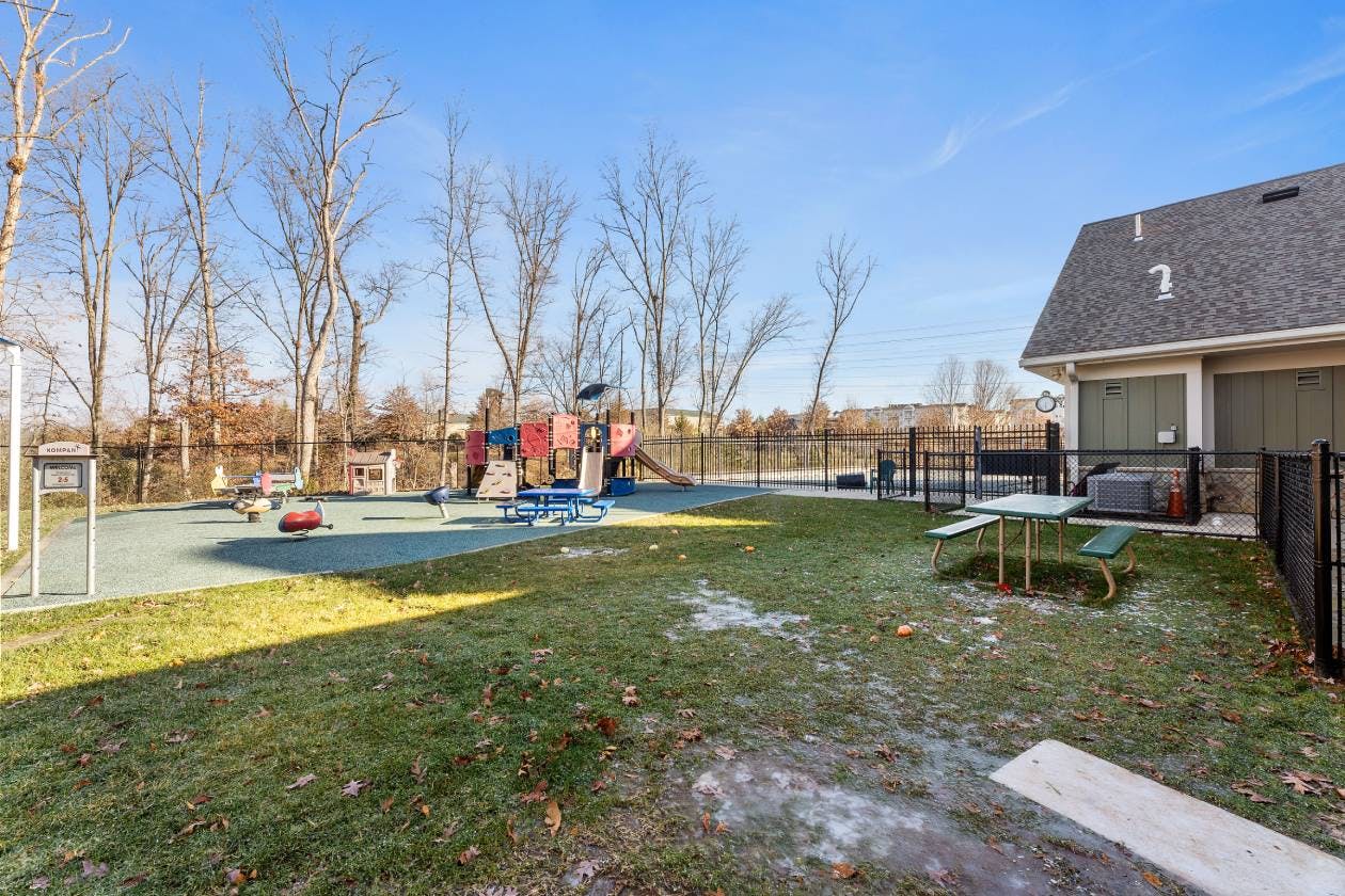 Outdoor playground with slides, swings, and climbing structures on a sunny day
