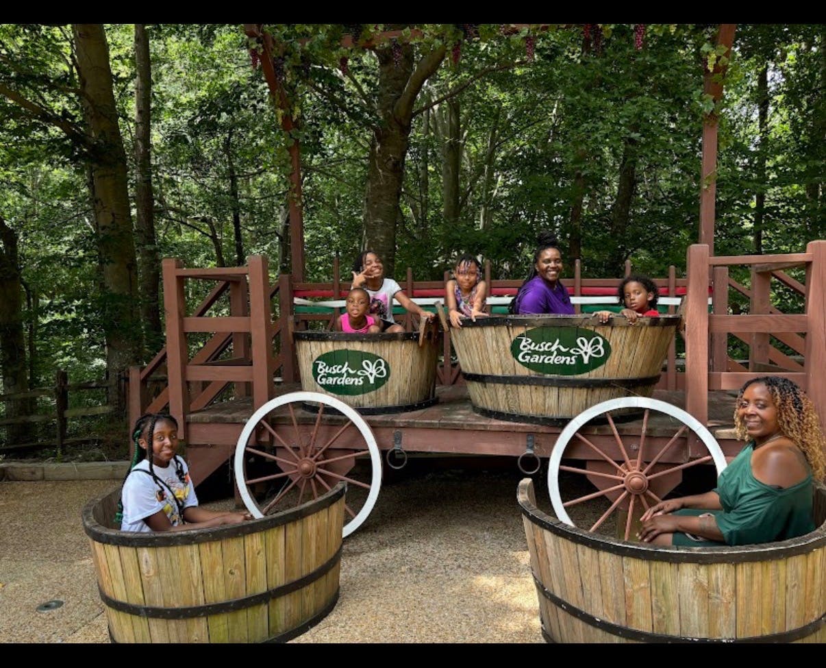People and children sitting in large wooden barrels at Busch Gardens