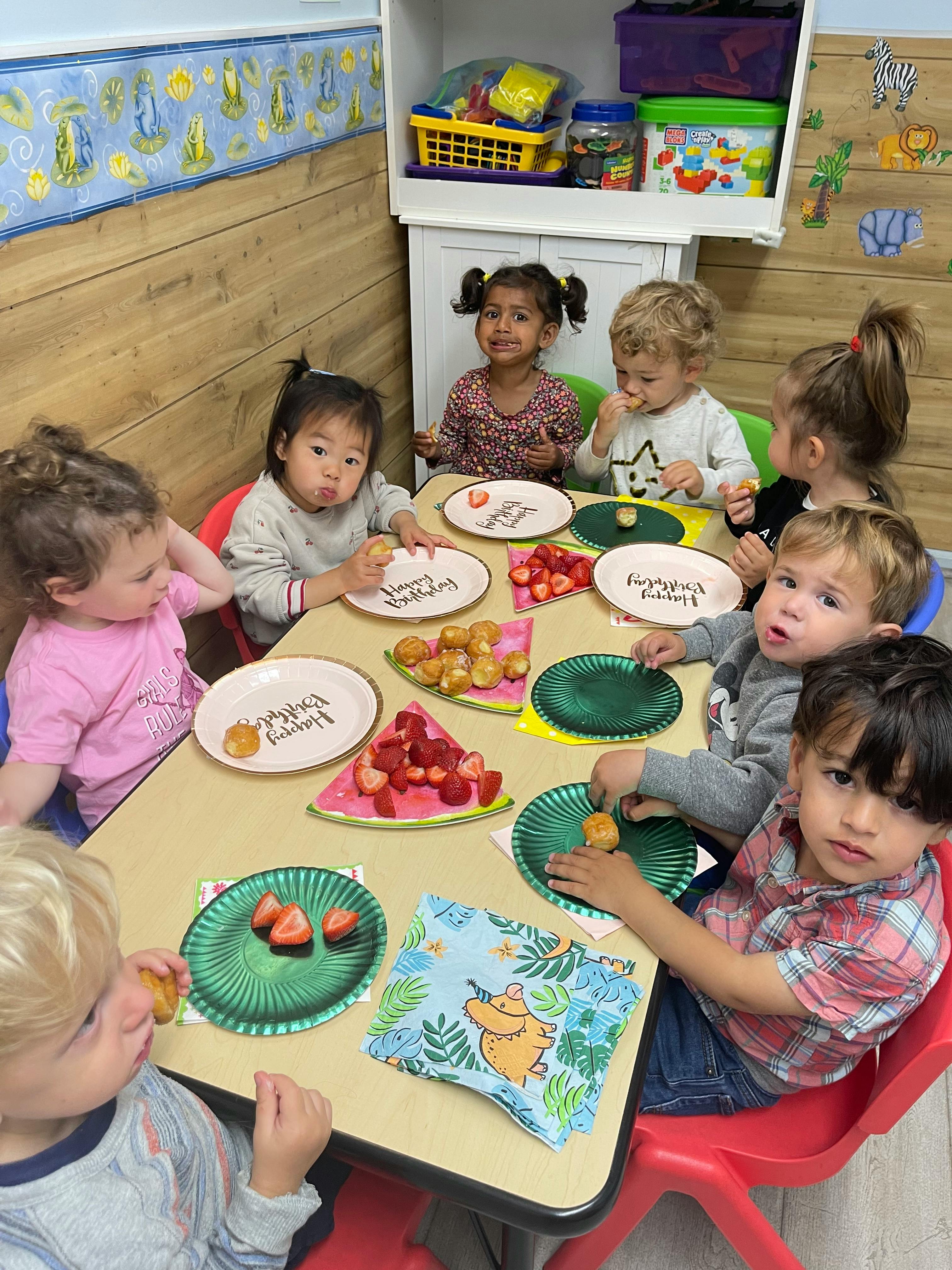 Children sitting at a table with plates of food