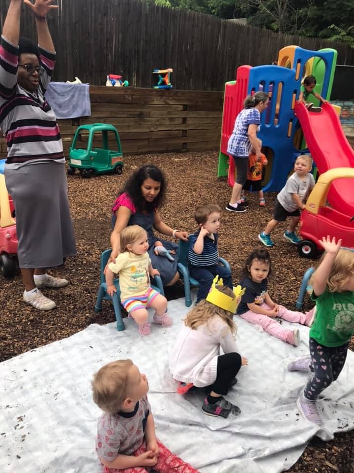 Adults and children playing outdoors with playground equipment
