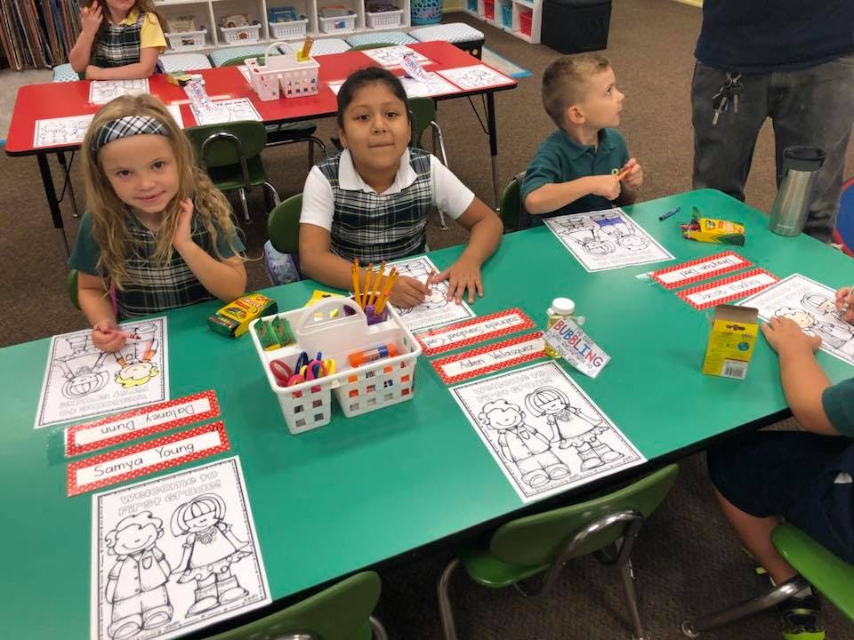 Children coloring at a table in a classroom