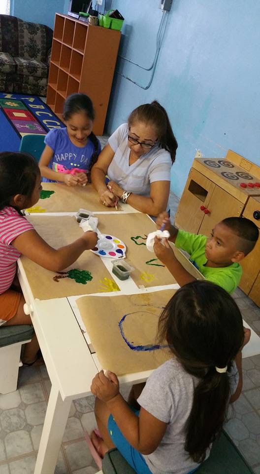 Adult and children painting at a table