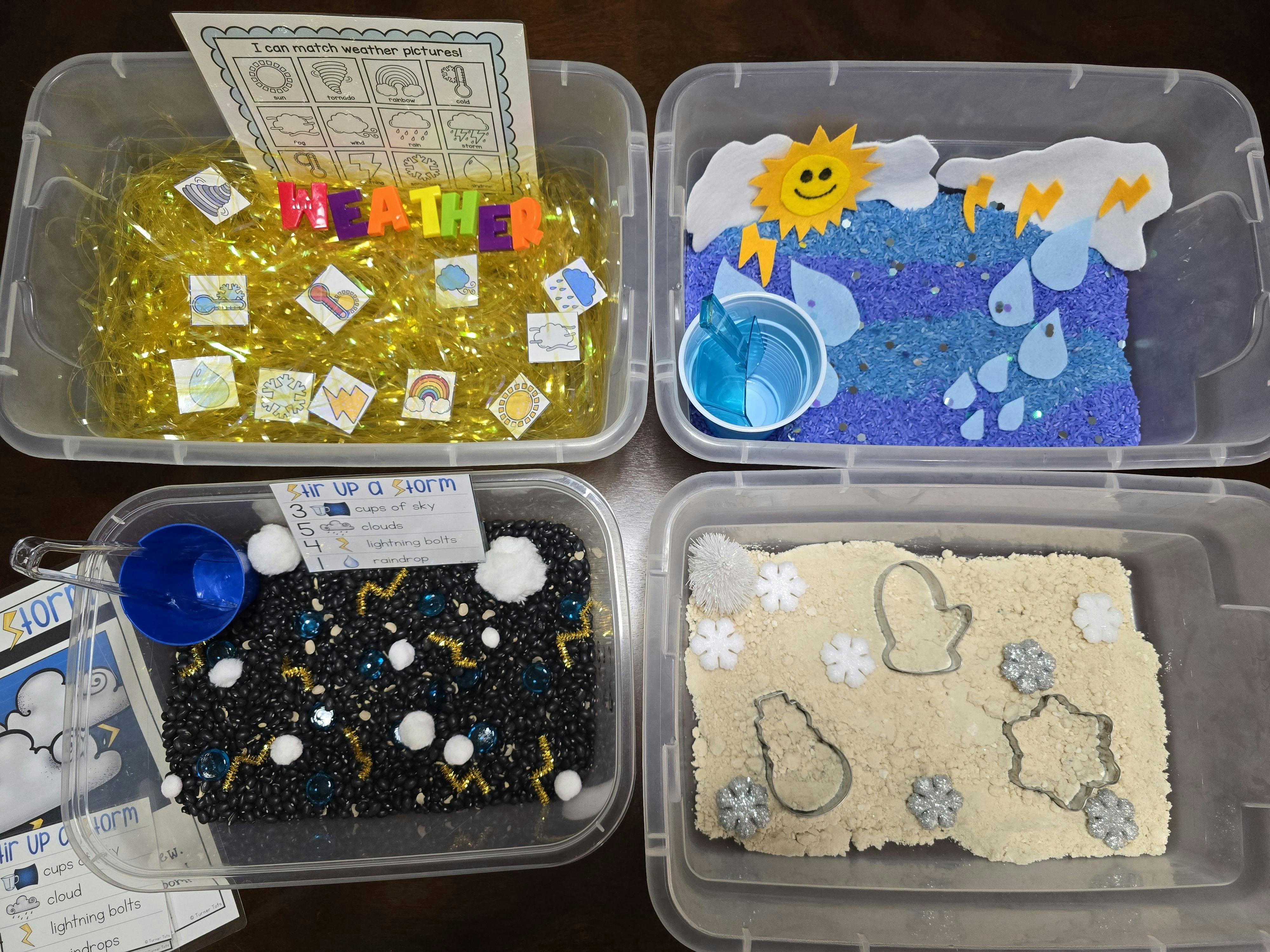 Four clear plastic bins with weather-themed sensory play materials