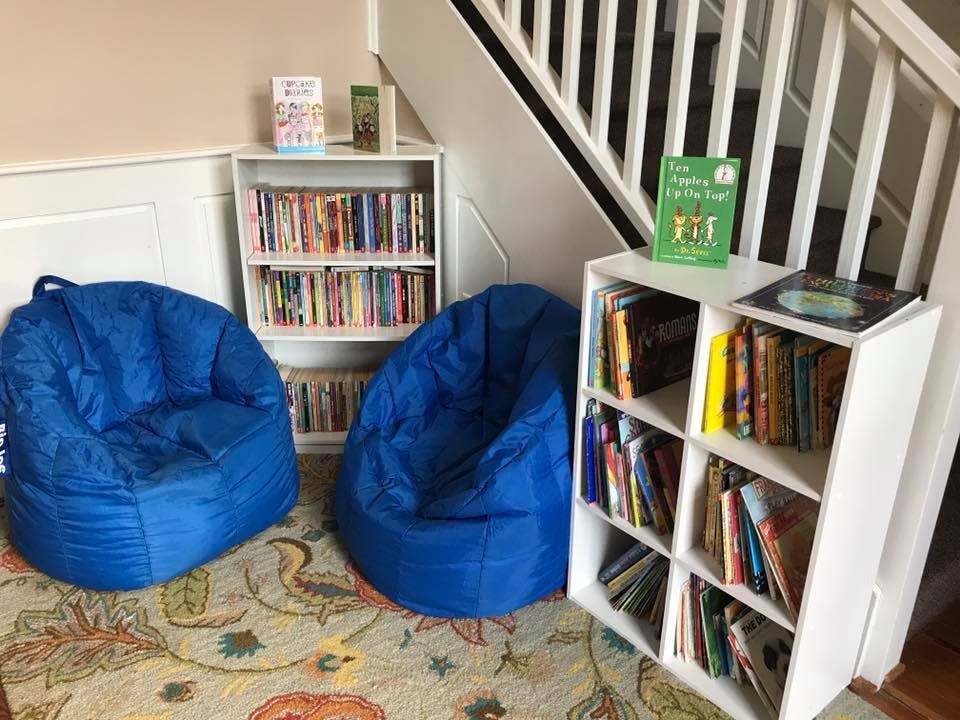 Two blue beanbag chairs and bookshelves with books