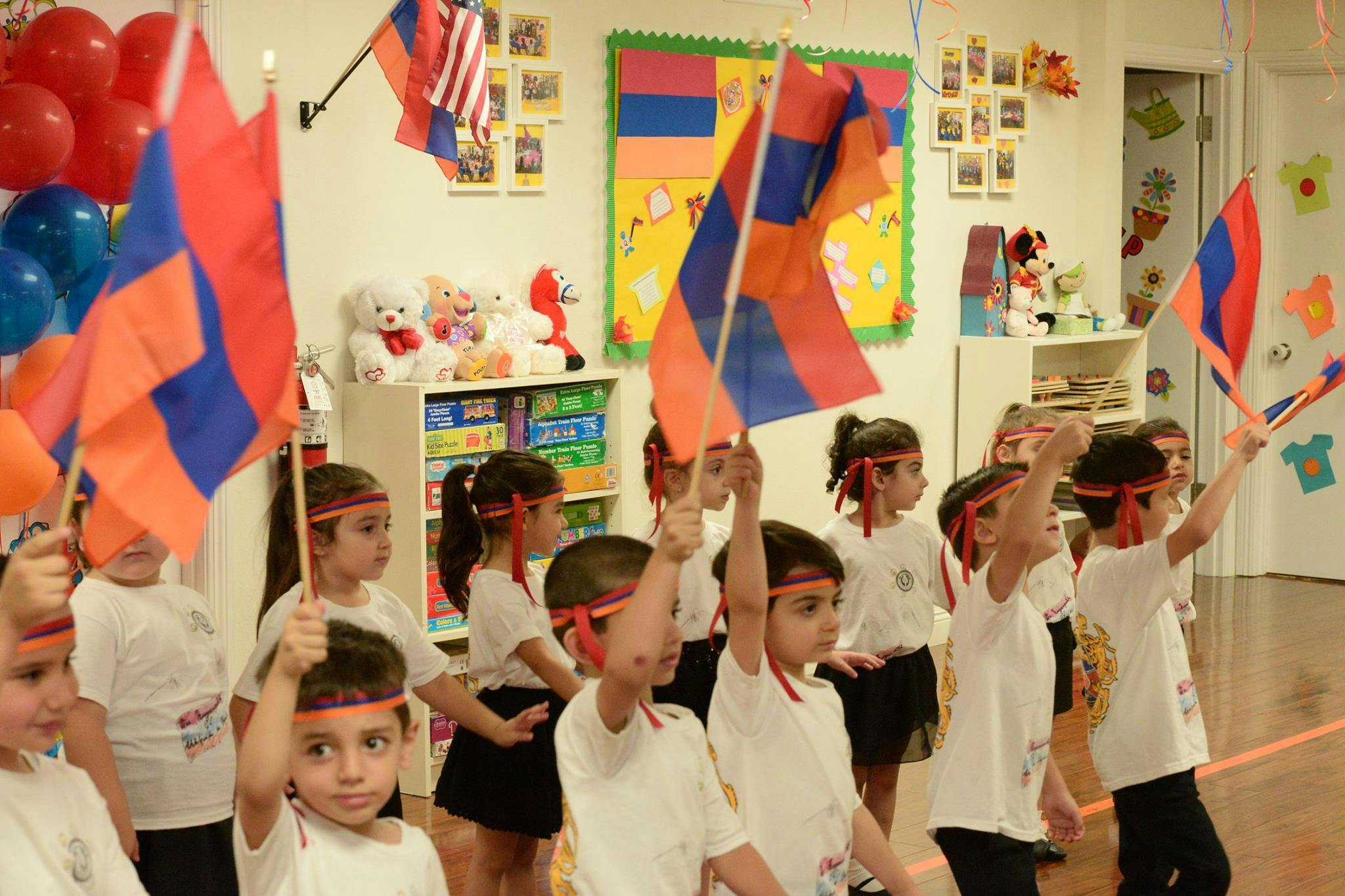 Children holding small flags in a classroom