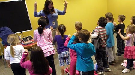 Adult leading a group of children in an activity