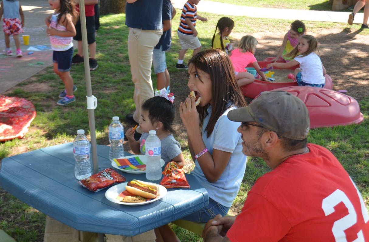 People eating at a picnic table outdoors