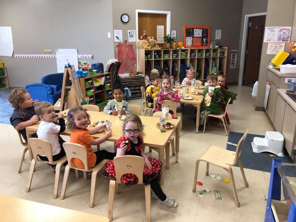 Children sitting at tables in a classroom