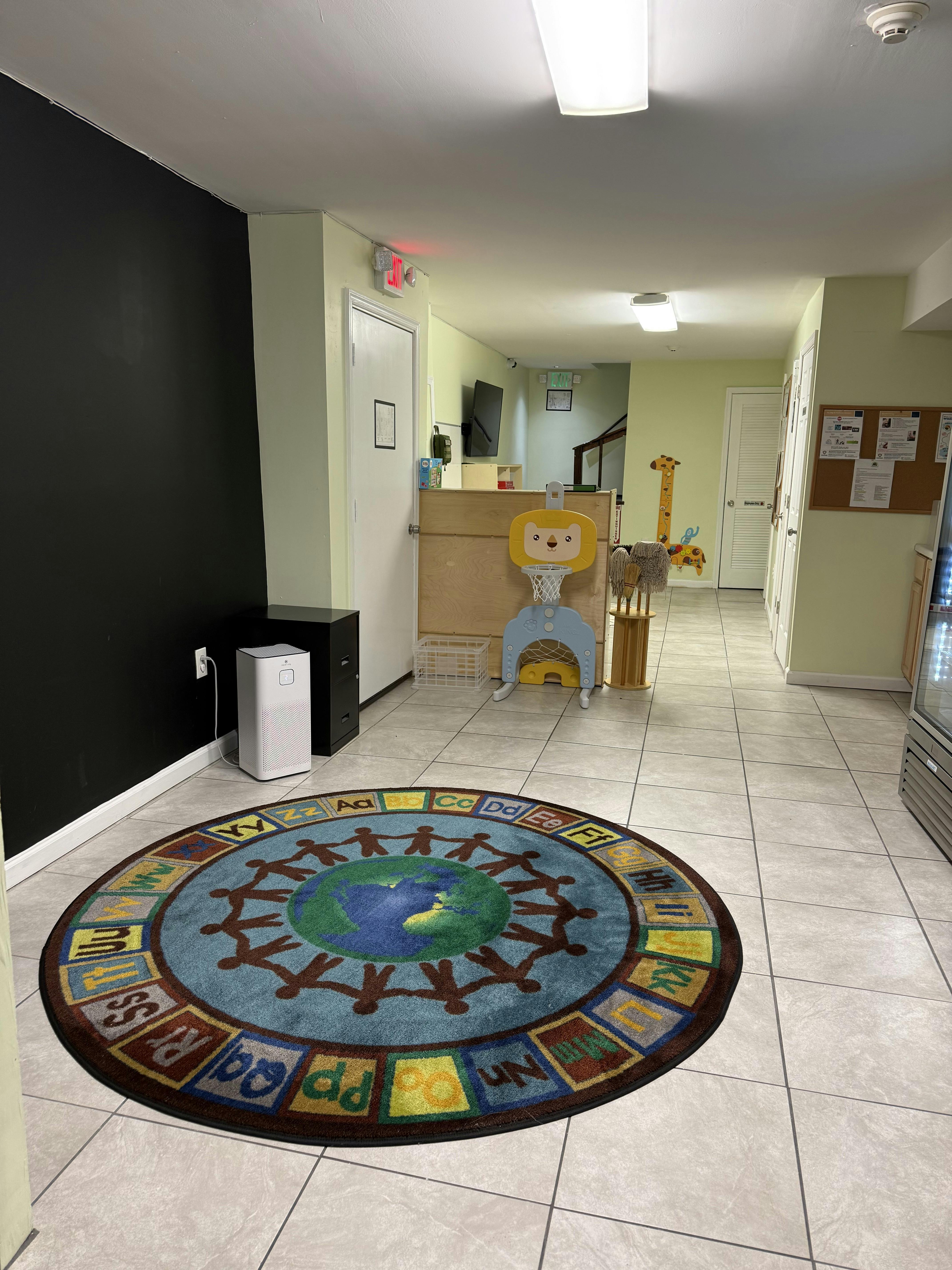 Round rug with a globe in the center and people holding hands around it