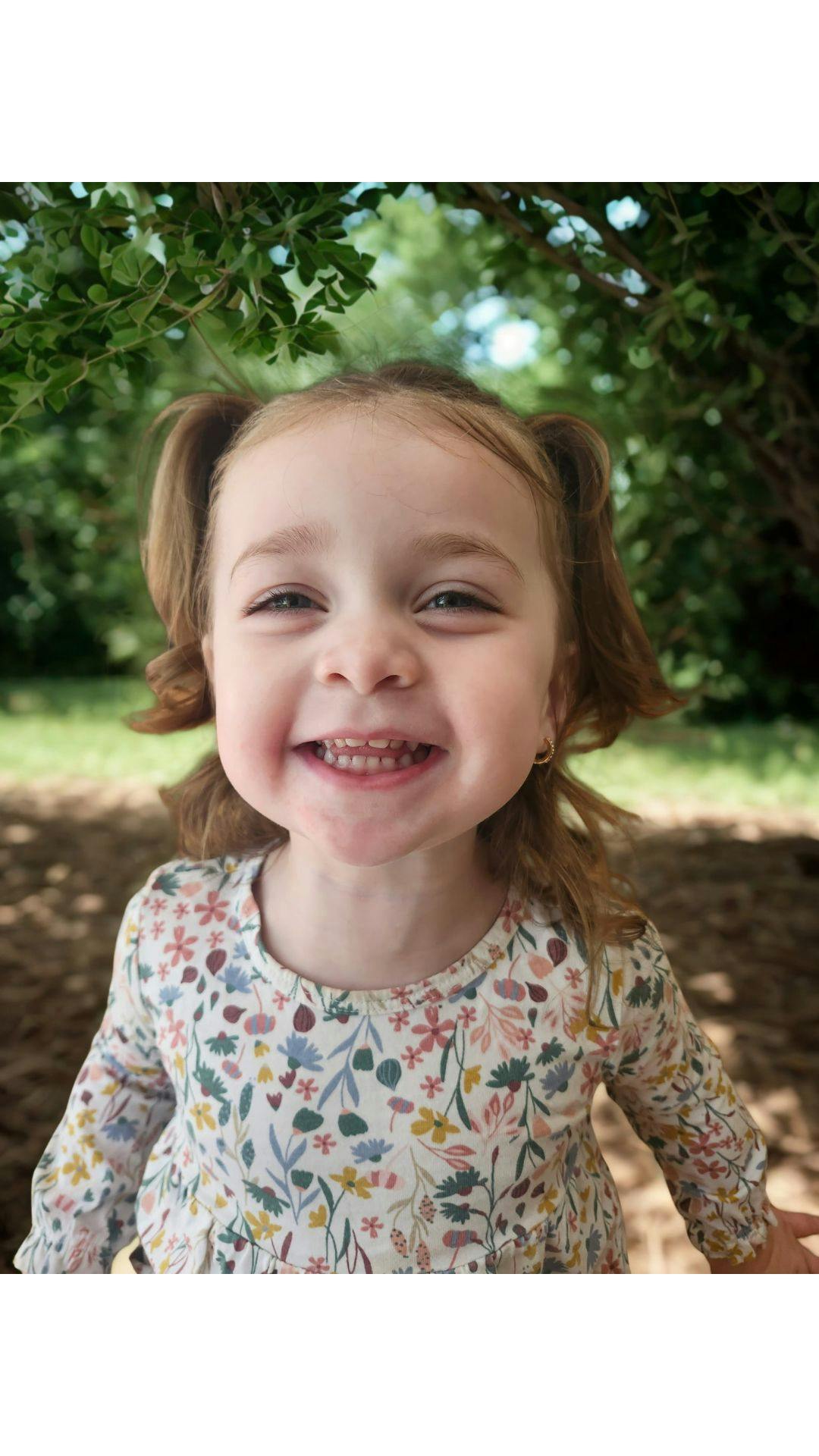 Close up of a young child smiling outdoors