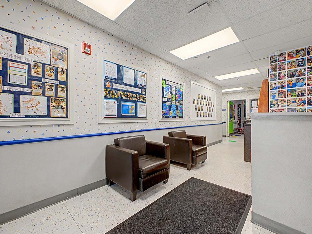 Hallway in a childcare center with children's artwork and two brown armchairs