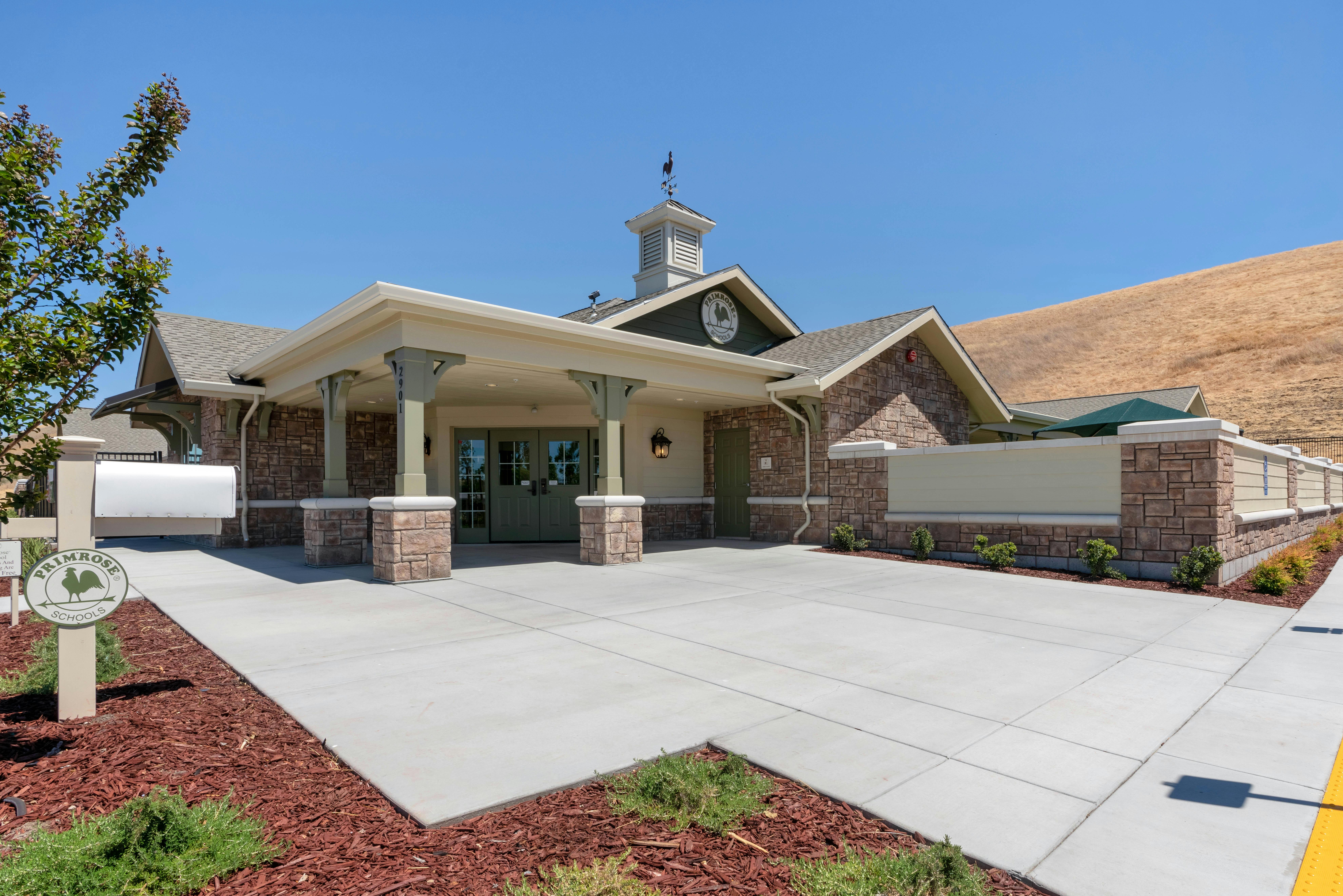 Exterior view of a Primrose Schools building entrance with a clear blue sky