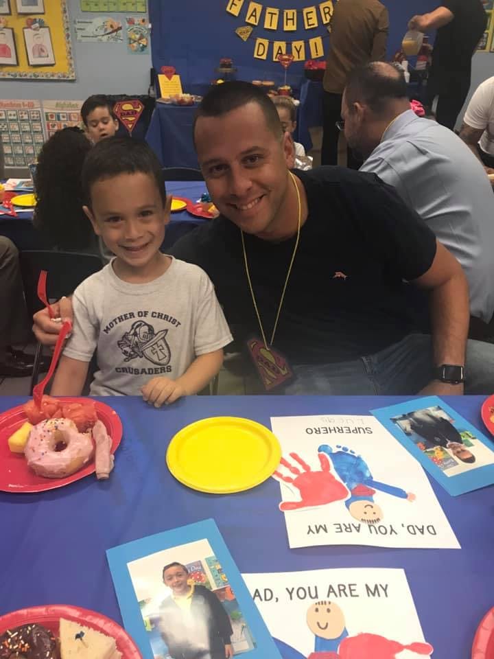 Adult and child sitting at a table with crafts and food