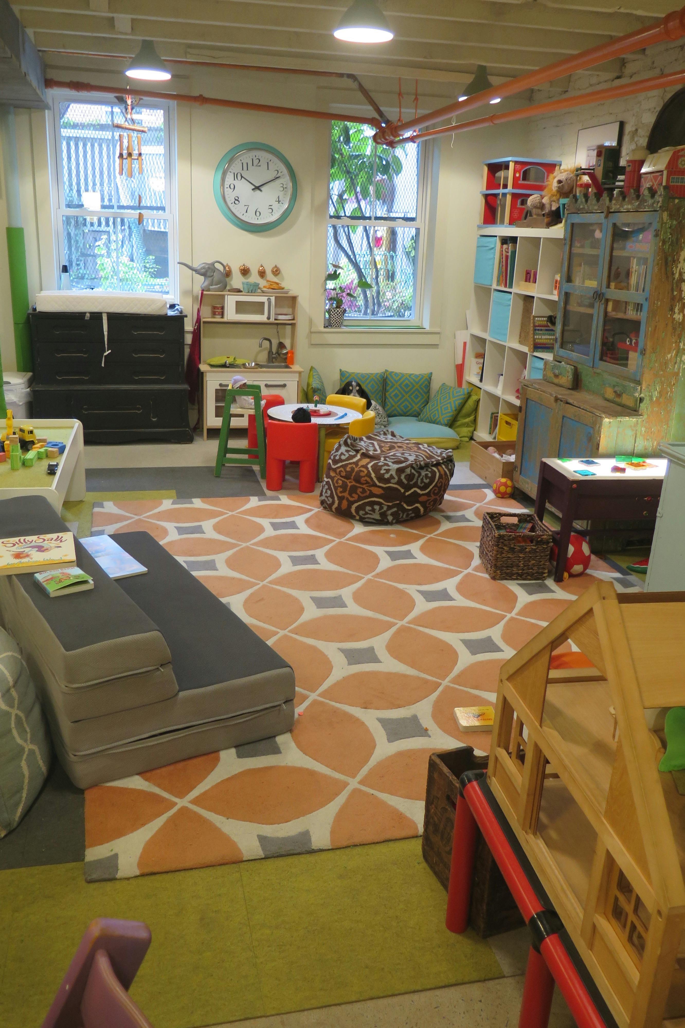 Playroom with a colorful rug, child-sized furniture, and toys