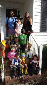Adults and children in costumes posing on steps