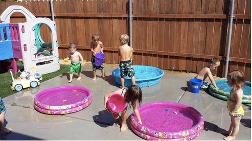 Children playing with water in small pools