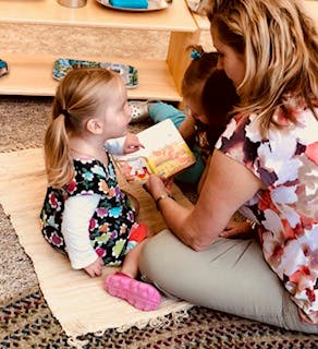 Adult and child reading a book together