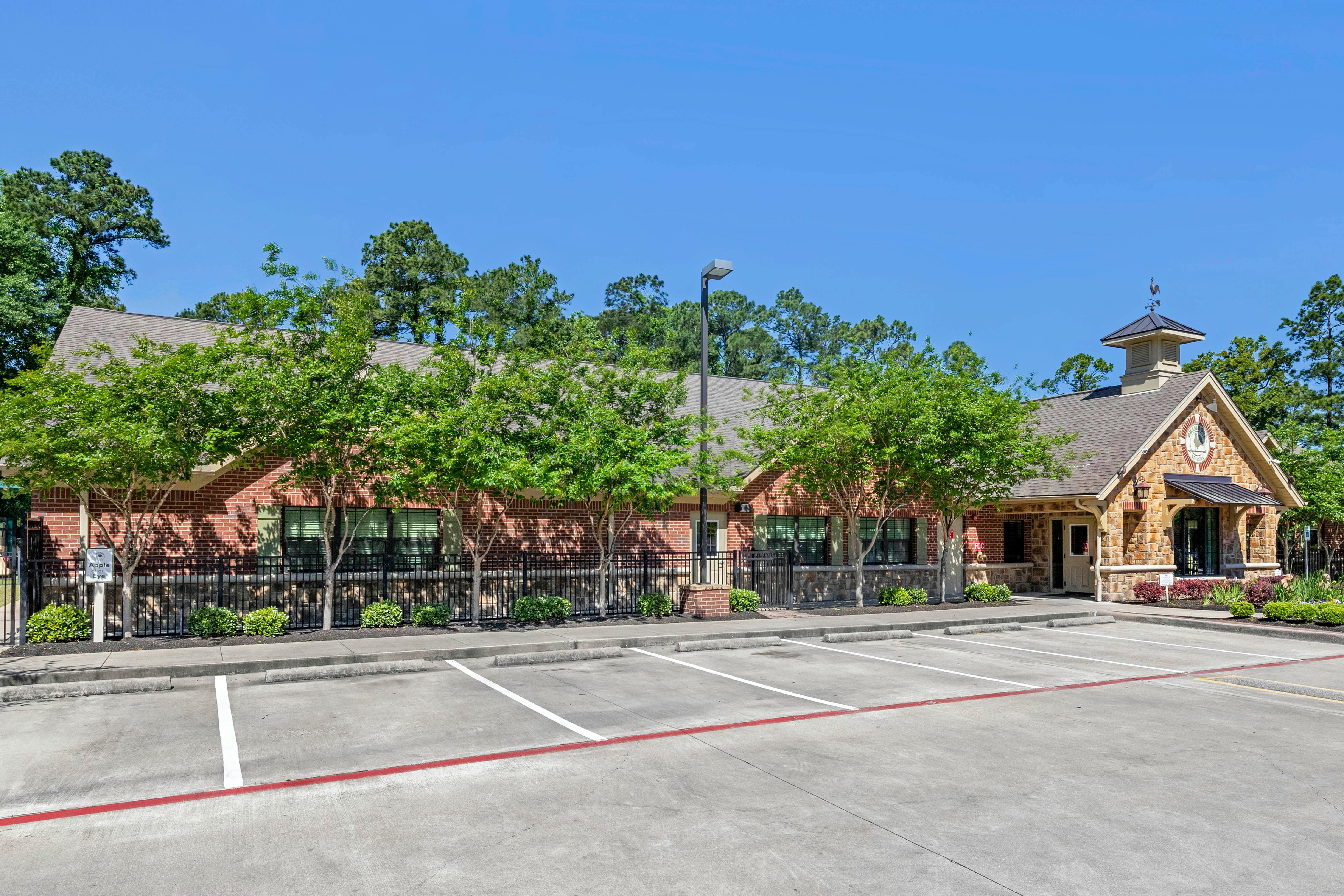 Brick building with a stone entrance and cupola next to a parking lot