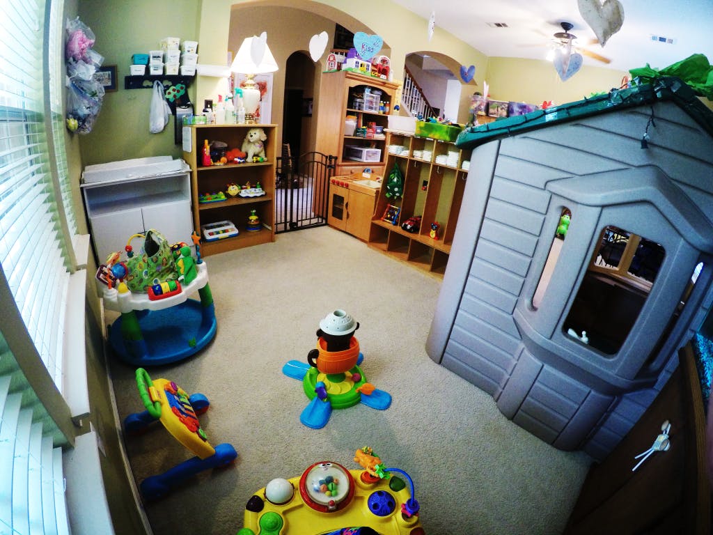Playroom with a playhouse, baby activity center, and toys on the floor