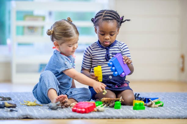 Two children playing with toys on a rug