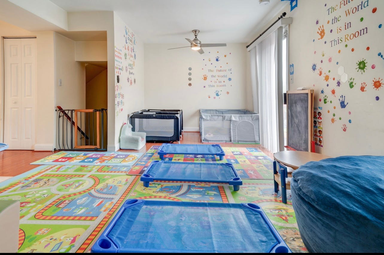 Daycare room with blue cots on a colorful rug