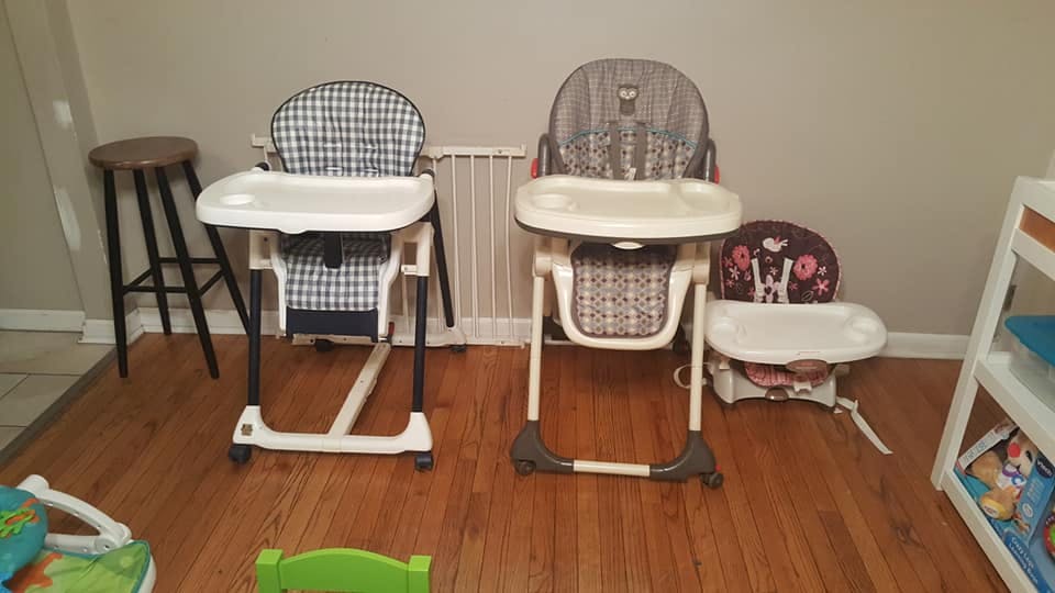 Two high chairs and a booster seat on a wooden floor