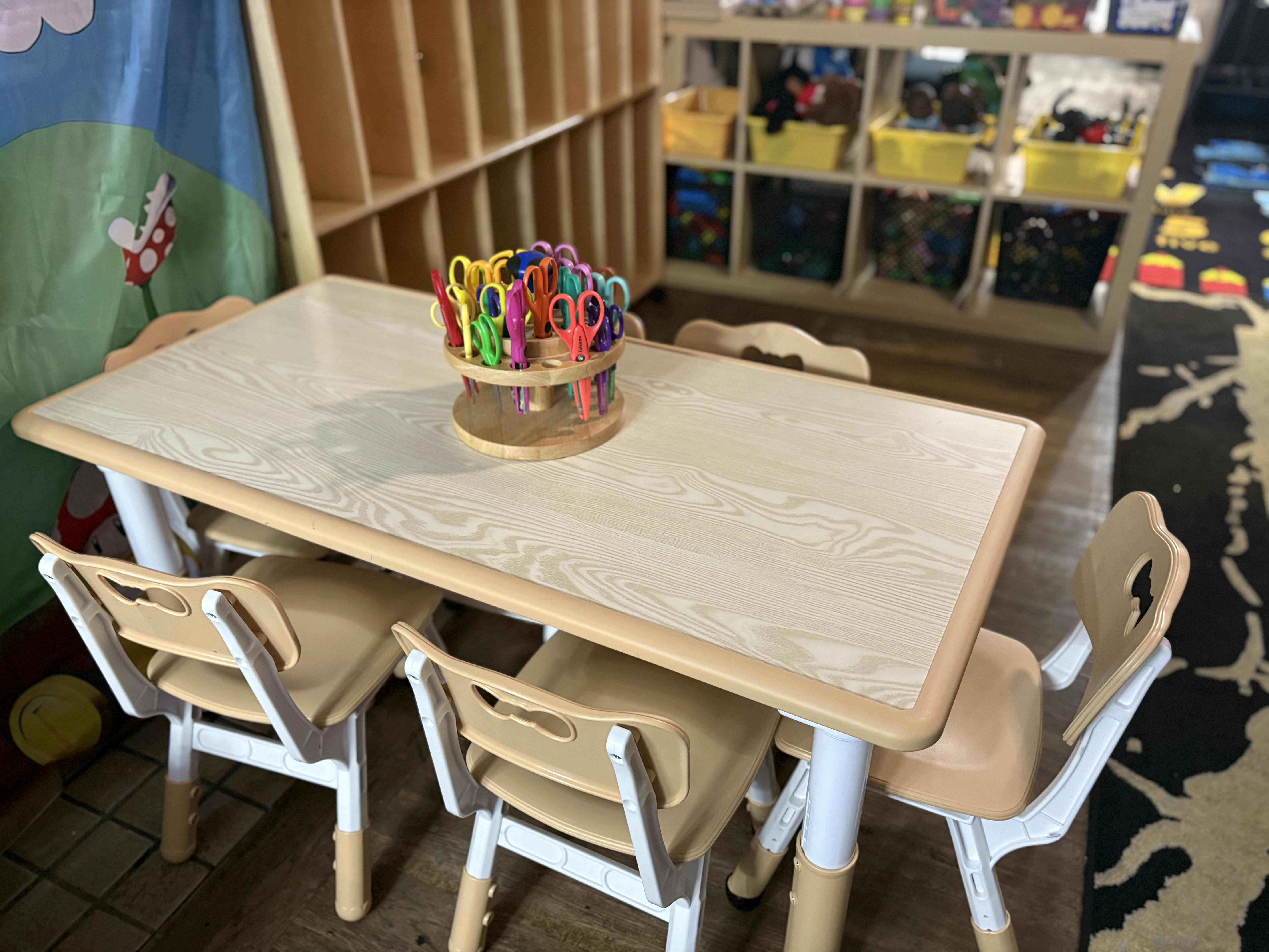 Child size table and chairs with a carousel of scissors in a classroom