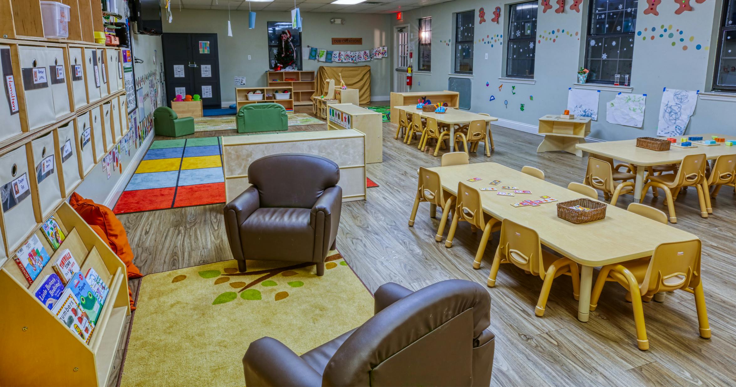 Colorful and organized classroom with small tables, chairs, shelves, and play areas