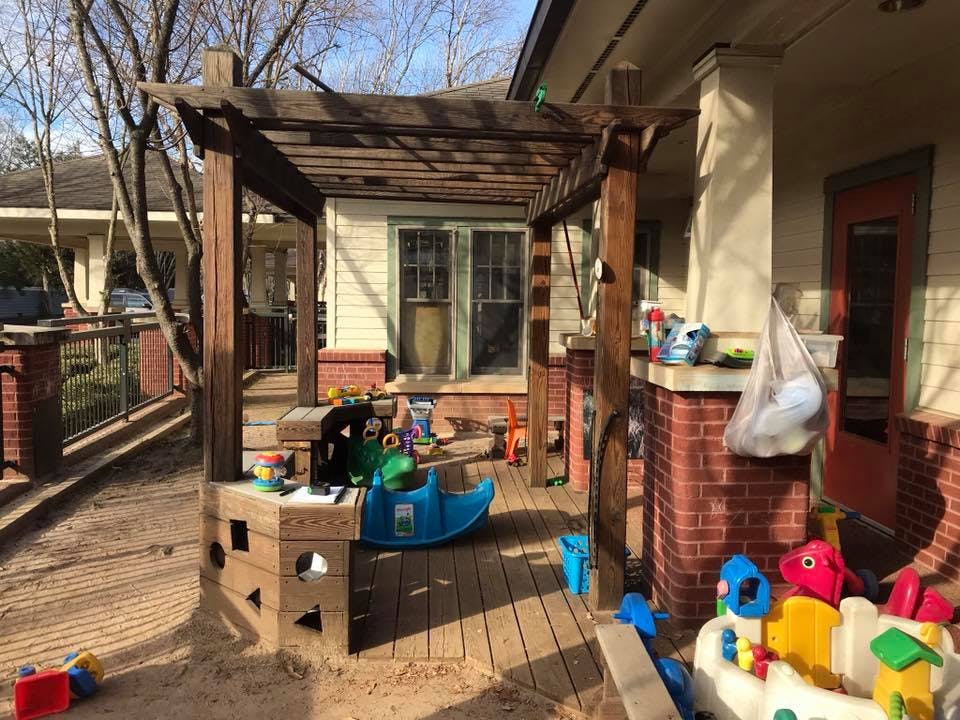 Outdoor patio with wooden pergola and children's toys