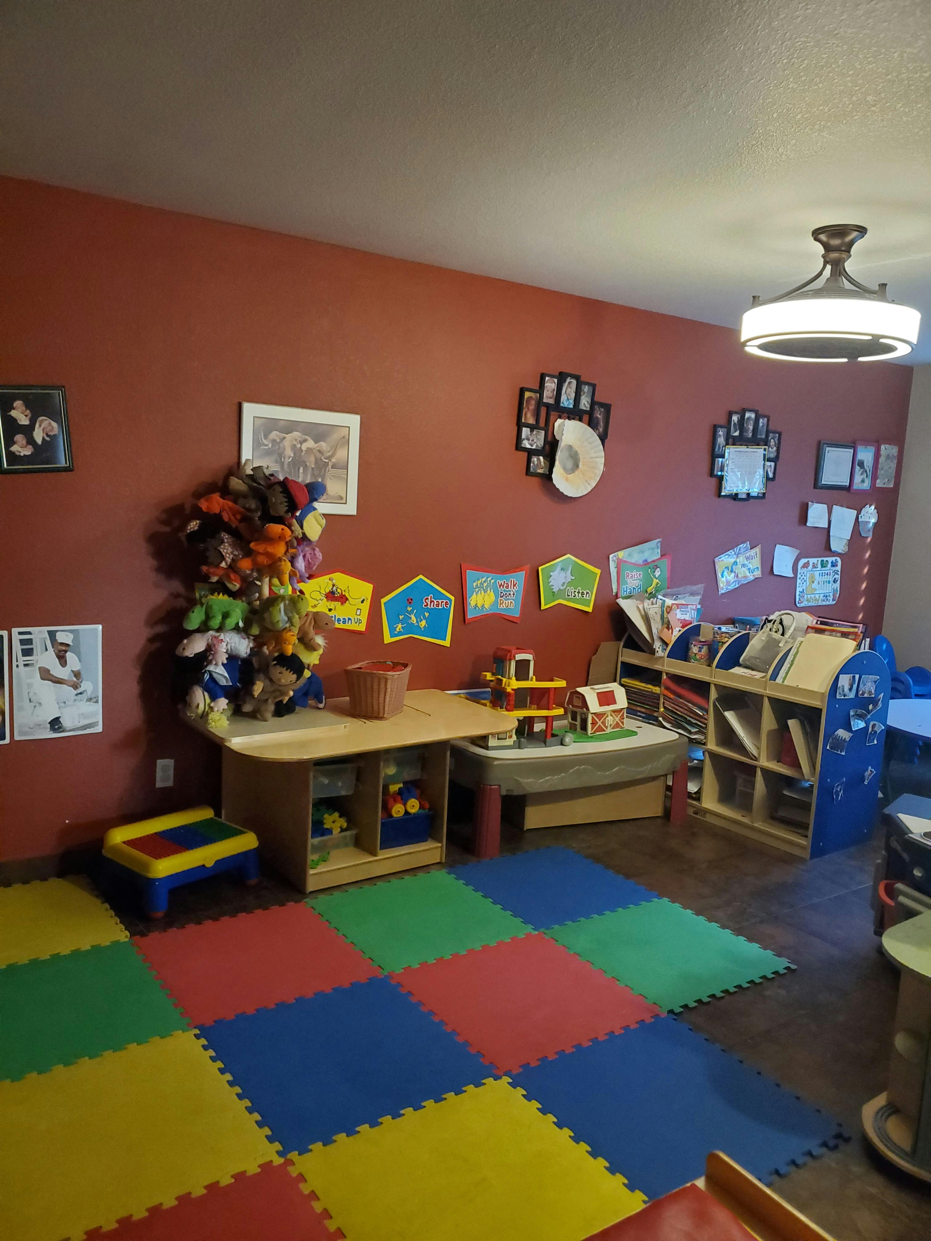 Playroom with colorful floor mats, toys, and shelves