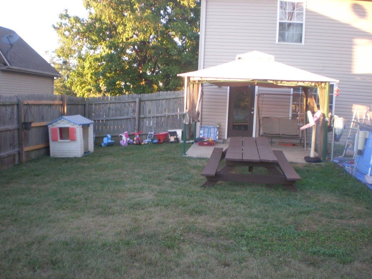Backyard with a picnic table, playhouse, and gazebo