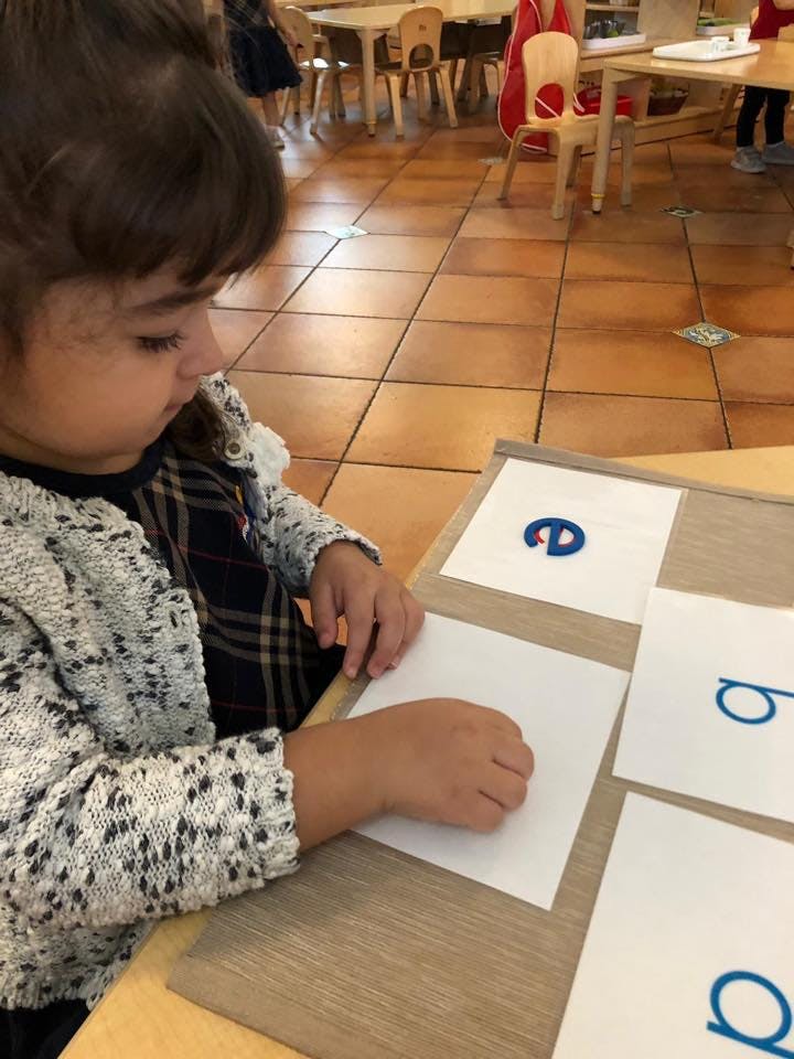 Child working with letter cards at a table